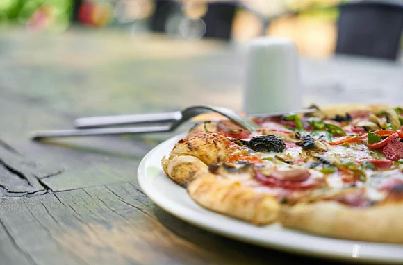 Nybakad pizza framför vedugnen på Pizzeria Furulund